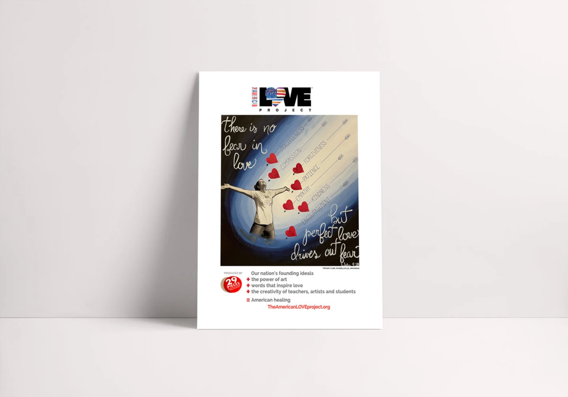 Poster mockup featuring artwork of arrows with hearts and words like 'peacefulness', 'compassion', and 'patience', flying toward a figure with outstretched arms, along with the text 'There is no fear in love, but perfect love drives out fear.'