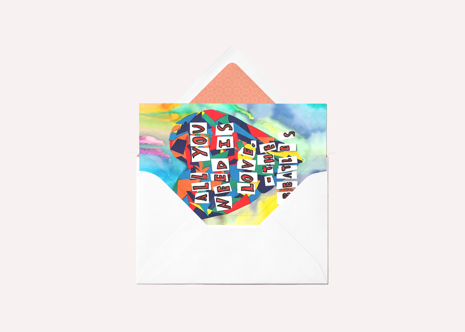 Greeting card mockup featuring artwork with a tie dye heart and cutout letters that spell the quote 'All You Need Is Love, The Beatles'