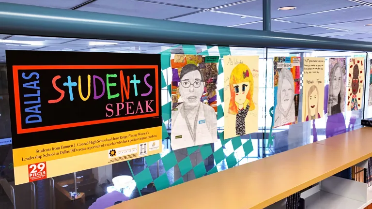 A glass wall inside a school is lined with student-made drawings of teachers. At the front of the display is a poster with the Dallas Students Speak and 29 Pieces logos.