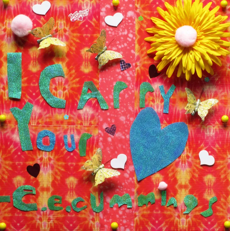 A colorful three-dimensional collage featuring a yellow flower, butterflies, hearts and beads with a quote by E. E. Cummings that reads, 'I carry your...' next to a cutout of a heart.