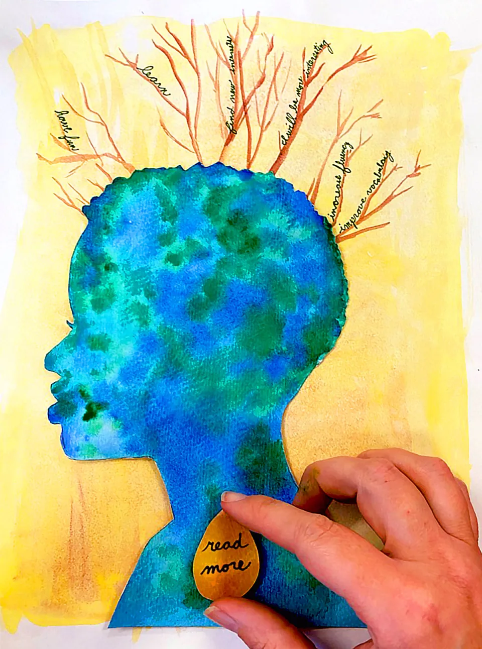 A hand places a gold pendant with the text, "Read More," over a watercolor collage of a student’s silhouetted face against a yellow background. Above the student’s head, branches emerge with scrawling text describing the student's goals, including “have fun,” “learn,” “find new interests,” and “improve vocabulary.”