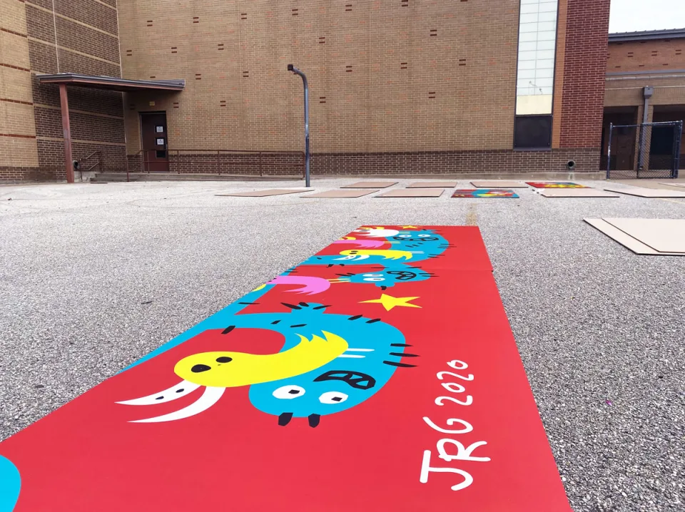 Dozens of rectangular sections of the Salazar Elementary mural are laid out on the ground in the school's courtyard.