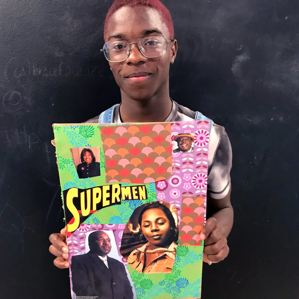A young man holds a collage with cutout photos of artists and other figures, patterned paper, and the word "Supermen"